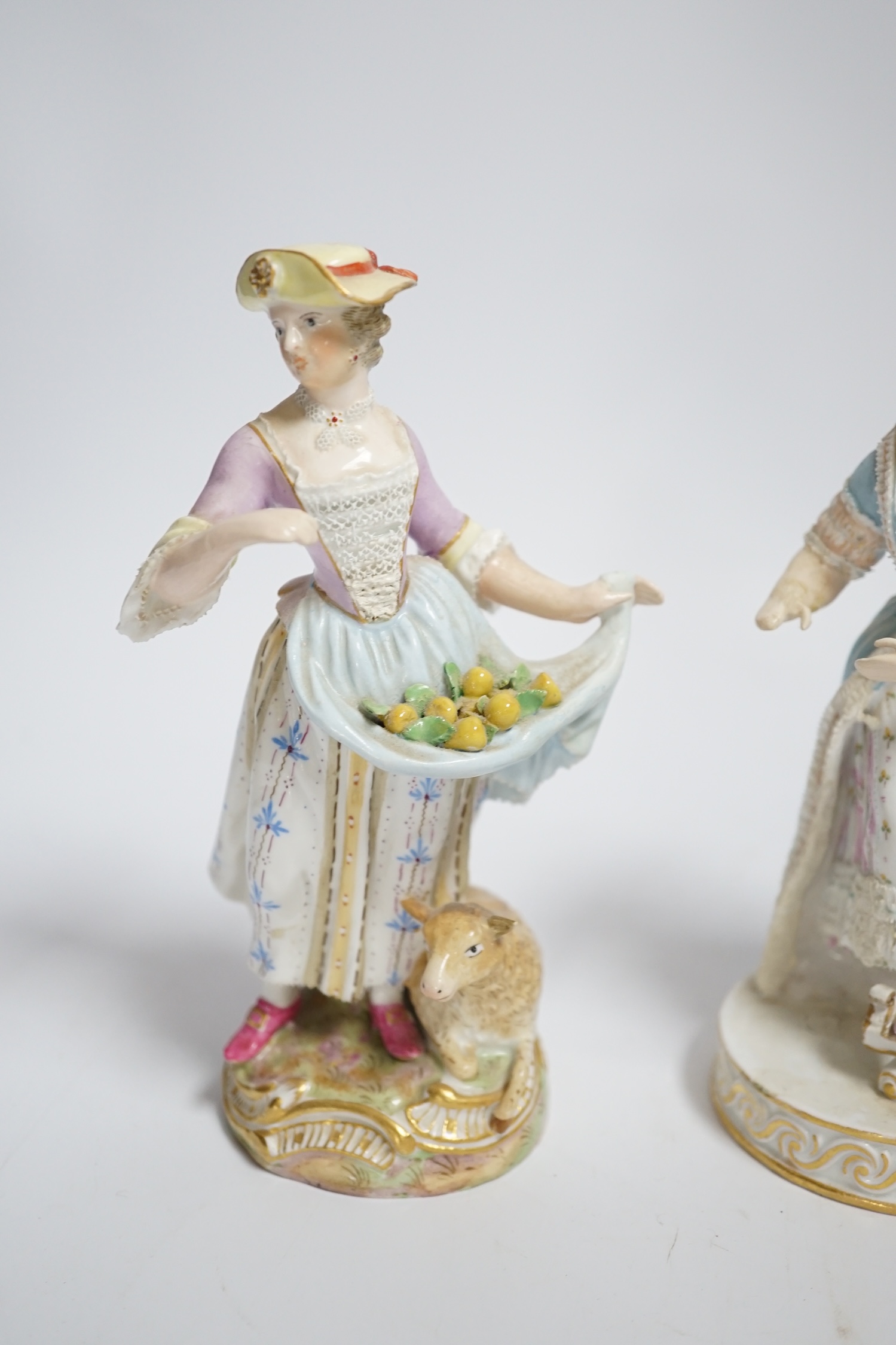 A late Meissen porcelain figure of a young woman wearing a black jacket and floral skirt on circular base, height 15cm and another similar figure (both with restored arms and hands), 15cm high